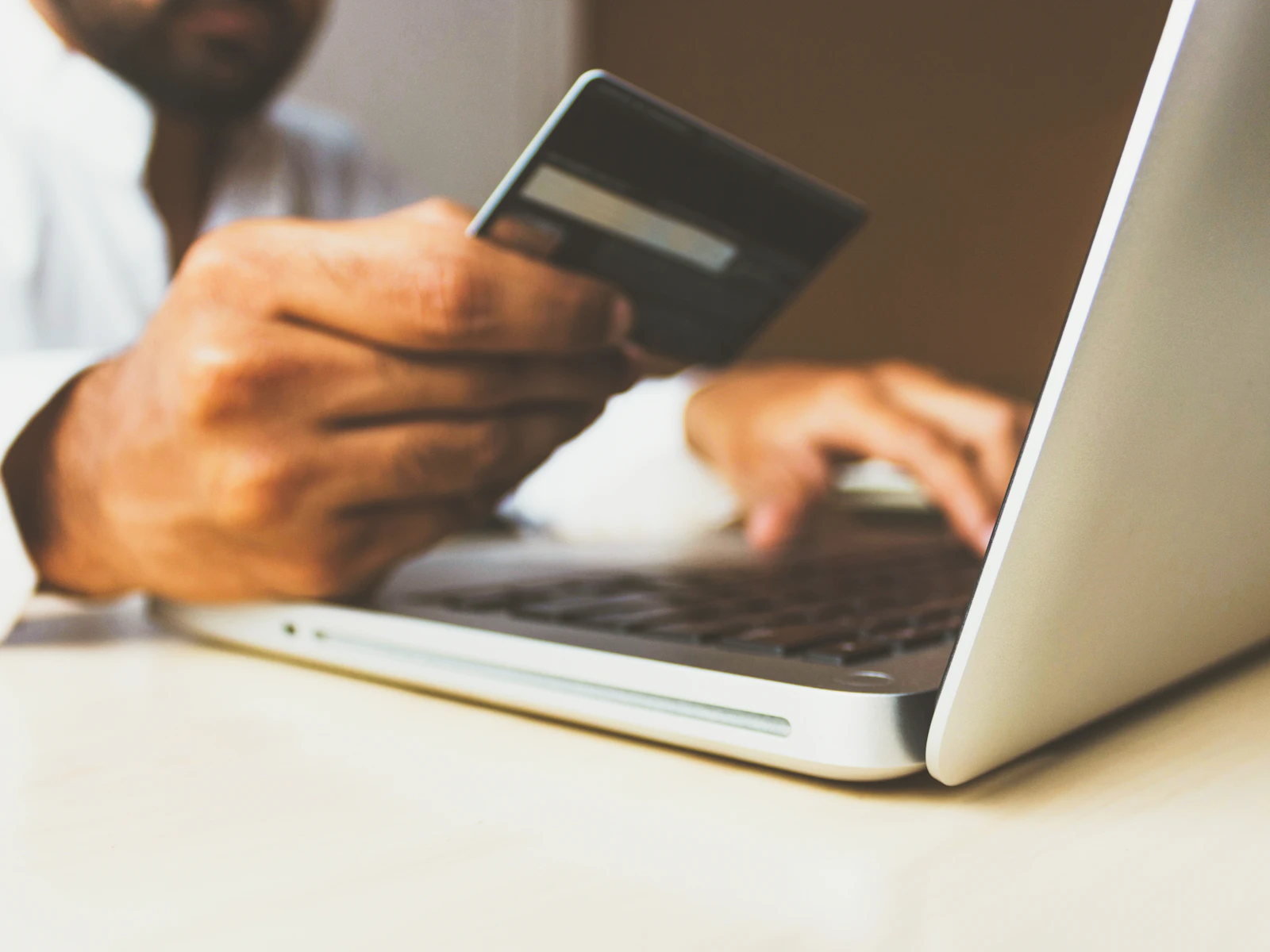 Person bezahlt am Laptop online mit Karte