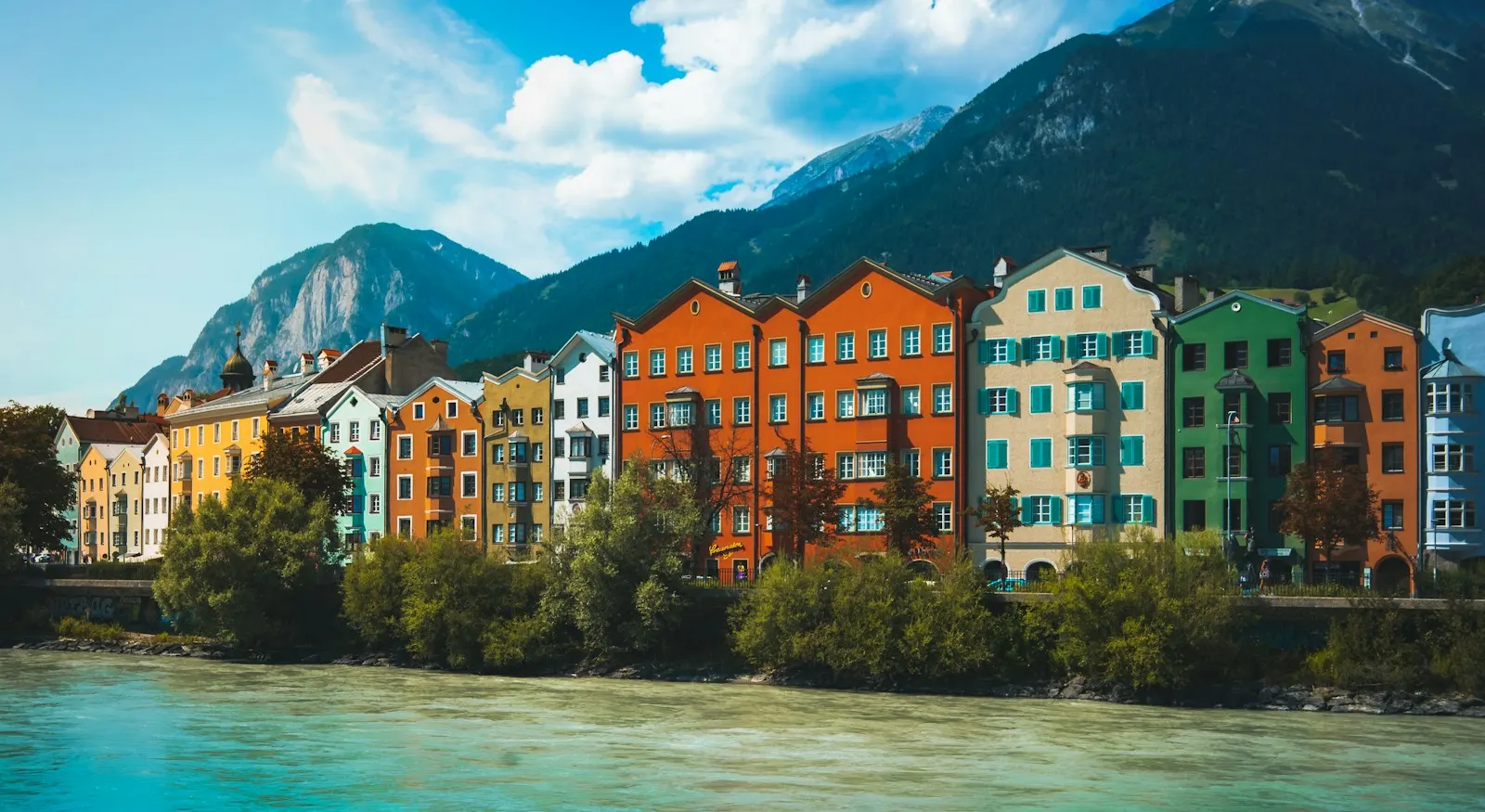 Inn mit bunten Häusern und Bergen in Innsbruck